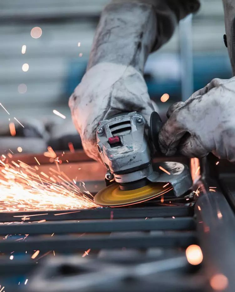 Hände halten eine Flex, die Funken sprüht. Foto: Pixabay|jannonivergall