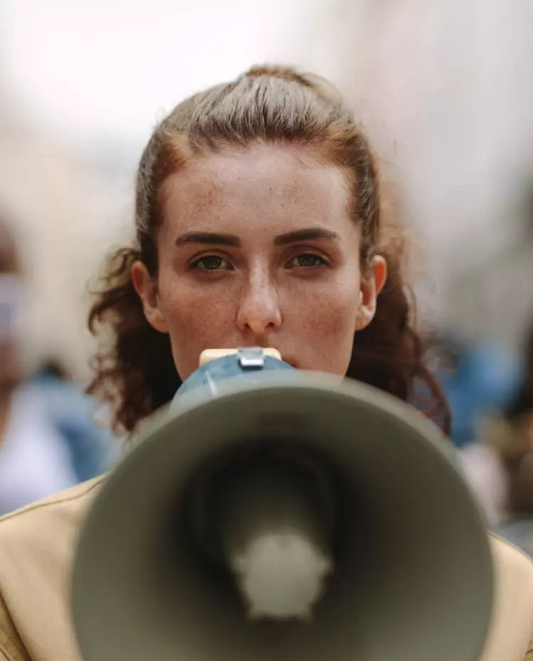 Eine Frau mit einem Megafon. Foto: Adobe Stock