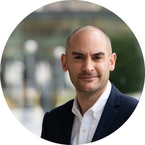 Potrait von Danyal Bayaz. Er trägt ein dunkles Sakko und ein weißes Hemd. Er hat eine Glatze, einen Drei-Tage-Bart und lächelt leicht.