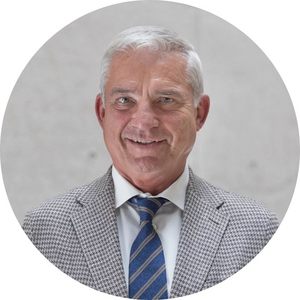 Portrait von Thomas Strobel, der graue Haare hat. Er trägt ein hellgraues Sakko, weißes Hemd und blaue Krawatte und lächelt in die Kamera.