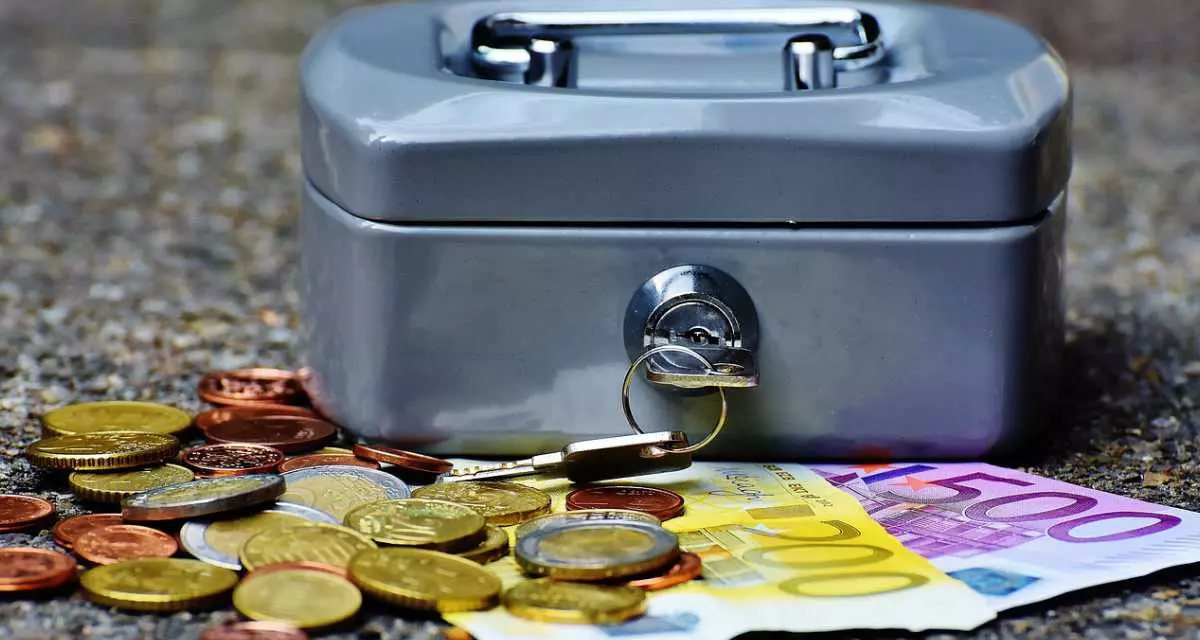 Eine Geldkassette, davor Euromünzen und -scheine.